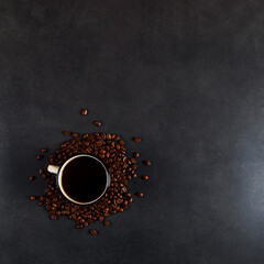 Black delicious coffee in an iron mug and scattered grains on a stone table. Authentic drink, copy space.