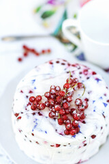 Homemade dessert of yogurt , berries and gelatin, decorated with raw red currants in white background with colorful napkin and cup, fresh, healthy food  concept