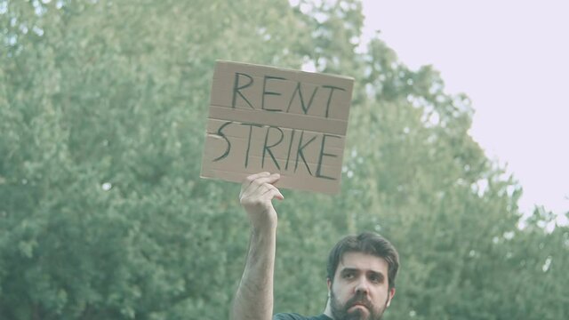 rent strike sign hold up