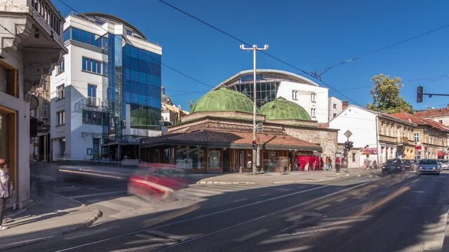 Bosniak Institute timelapse hyperlapse, in a renovated Turkish bathhouse, includes a library and art collection focusing on Bosniak culture. Street with cars and public transport at Sarajevo city
