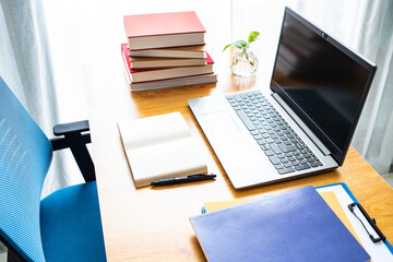 Laptop and book study materials on the desk