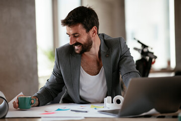 Young businessman working with laptop at office. Businessman sitting at office desk working on laptop computer..