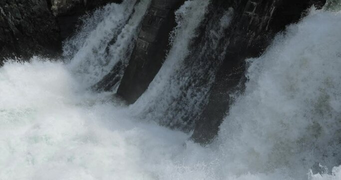 Waterfalls and streaming current on damaged hydroelectric power station on river. Beautiful view on HPP object. Water falling in river. Spring flood water flowing on hydroelectric power station dam.