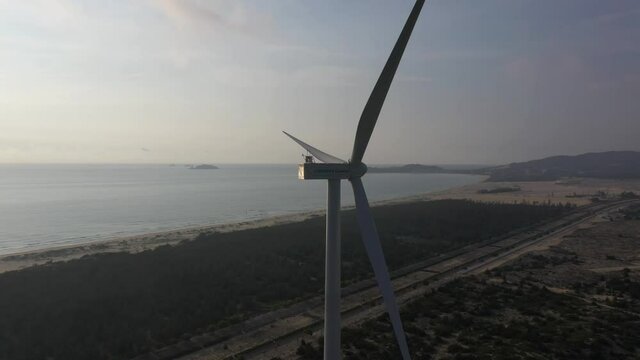 Aerial view of windmills farm for energy production on beautiful cloudy sky at beach. Wind power turbines generating clean renewable energy for sustainable development, Quy Nhon, Binh Dinh, Vietnam