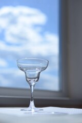 empty glass for cocktails or martini on blue sky background