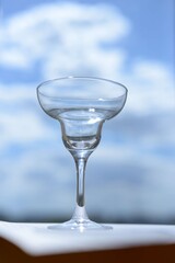 empty glass for cocktails or martini on blue sky background