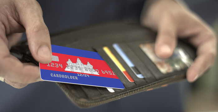 Man pulls plastic bank card with flag of Cambodia out of his wallet, fictional card number