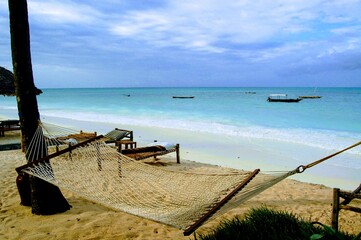 Obraz premium Hammock on the beach with clear blue waters in Zanzibar