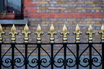 Classic black metal fence with golden tips as background