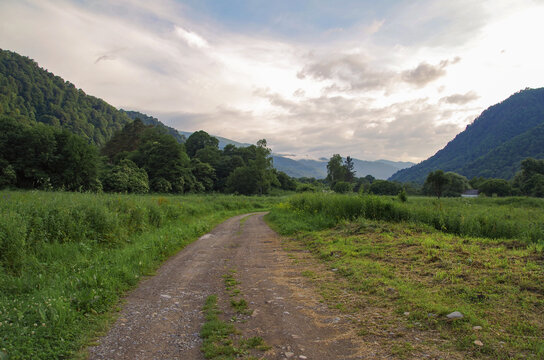 Caucasus mountains. Dirt road and mountain valley at evening. Nature and travel. Russia, Karachay&ndash;Cherkessia, Nizhnearkhyzskoe gorodishche near Arkhyz