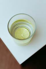 Glass of water with fresh lemon on the corner of the table