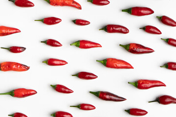 red chillies spread out on white background