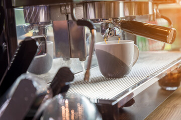Coffee extraction from professional coffee machine. coffee machine preparing fresh coffee and pouring into cups at restaurant, bar or pub. Espresso shot from machine.