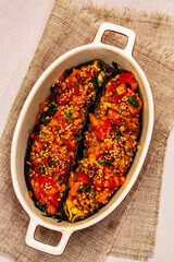 Karniyarik traditional Turkish food from stuffed eggplants with minced meat, tomato, greens and sesame seeds