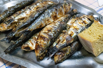grilled sardines with bread on a plate