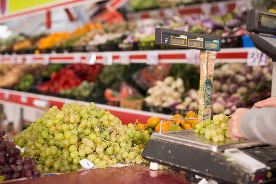 Weighing grapes on the scales at the grocery store. High quality photo