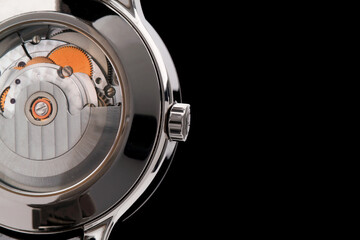 Close view of watch mechanism isolated on black background. Space for your text.