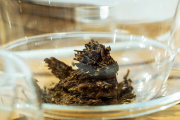 dry black tea in a glass bowl. Macro shot.