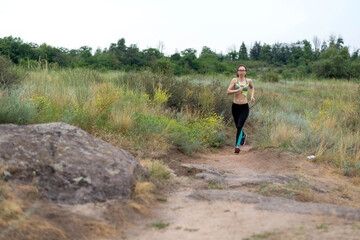 Woman runner running on rocky terrain, free space.