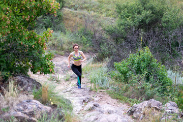 Woman runner running on rocky terrain, free space.