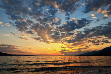 Naklejka na ściany i meble Beautifully sunset in the evening over sea with cloudy sky