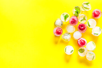 Berries and mint in ice cubes top view frame copy space
