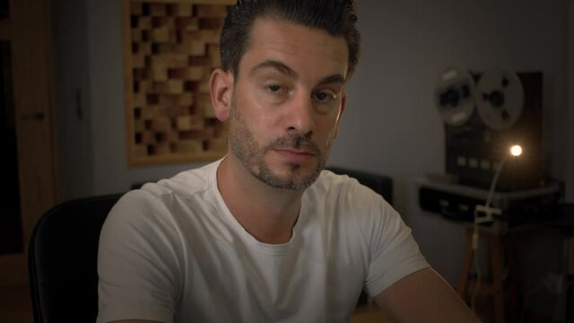 closeup portrait of music sound mastering engeneer in his studio with retro audio equipment on background