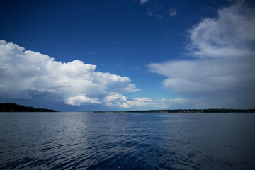 Obraz premium Clouds over a river on a summer day