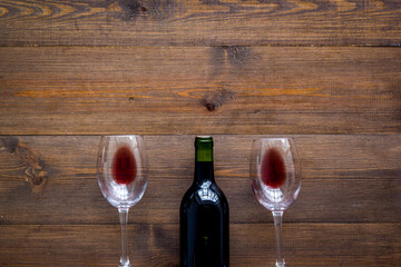 Wine bottle and glasses on wooden background from above copy space