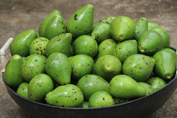 Basket full of avocados also called as butterfruit kept for sale