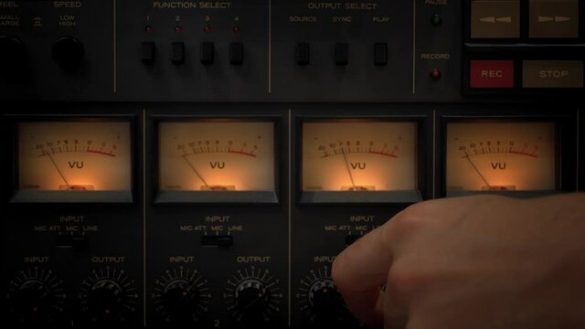 closeup of retro audio equipment with and mans hand setting it. retro audio tape recorder closeup
