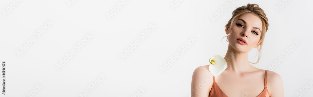 Wall mural elegant beautiful blonde woman holding calla flower on shoulder isolated on white, panoramic shot