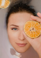 Beautiful young woman with clean fresh skin in a bathroom close-up.Cosmetology, beauty and spa.