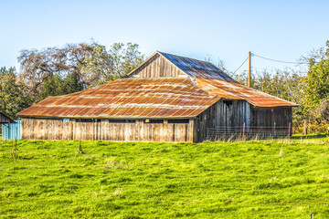 Obraz premium Old Leaning Wood Barn With Rusted Tin Roof