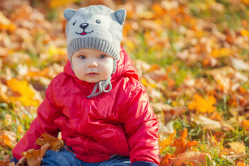 happy boy and fallen leaves playing in autumn park.