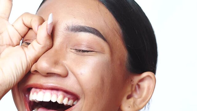 Closeup face of beautiful Asian woman looking at the camera doing doing circle, binocular with hand over white background
