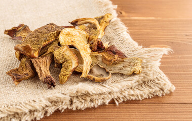 Dried mushrooms on burlap on a wooden background. Organic, eco-friendly food