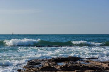 Aerial top view of sea waves hitting rocks on the beach
