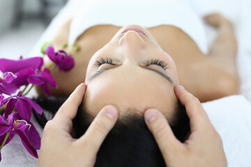 Woman is given facial massage at spa. Beauty salon services concept
