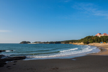 Aerial top view of sea waves hitting rocks on the beach