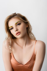 Naklejka premium beautiful blonde woman in silk dress with wildflowers on eyebrows isolated on white