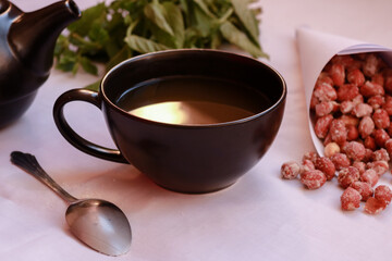 Warm tea cup with peanuts and mint