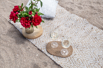 Fototapeta na wymiar Picnic by the sea with flowers and a glass of champagne