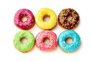 Sweet colorful glazed doughnuts from above on white background. Junk food top view, sugar treat