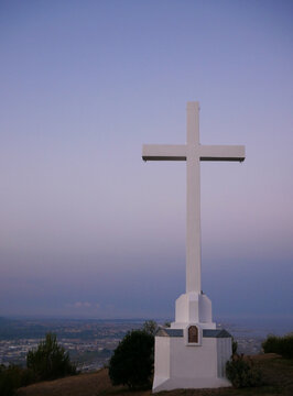 Metal religious cross over a hilltop during a sunset. Copy space