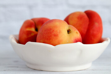 Ripe red-yellow bright peaches lie on a white plate. Healthy eating. Fruit diet. macro shooting