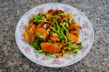 Fried sea bass fish with celery vegetables in dish