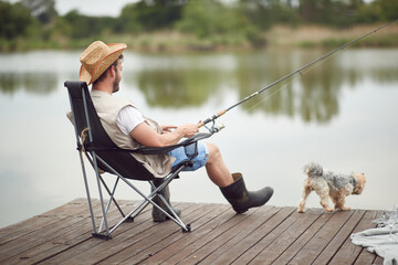 A man enjoying fishing with his dog