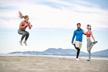 Fototapeta na wymiar Workout on the Beach. Runners working out. jumping and fitness workout on the beach.