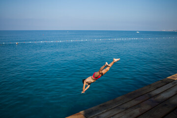 The boy jumped from the pier into the sea